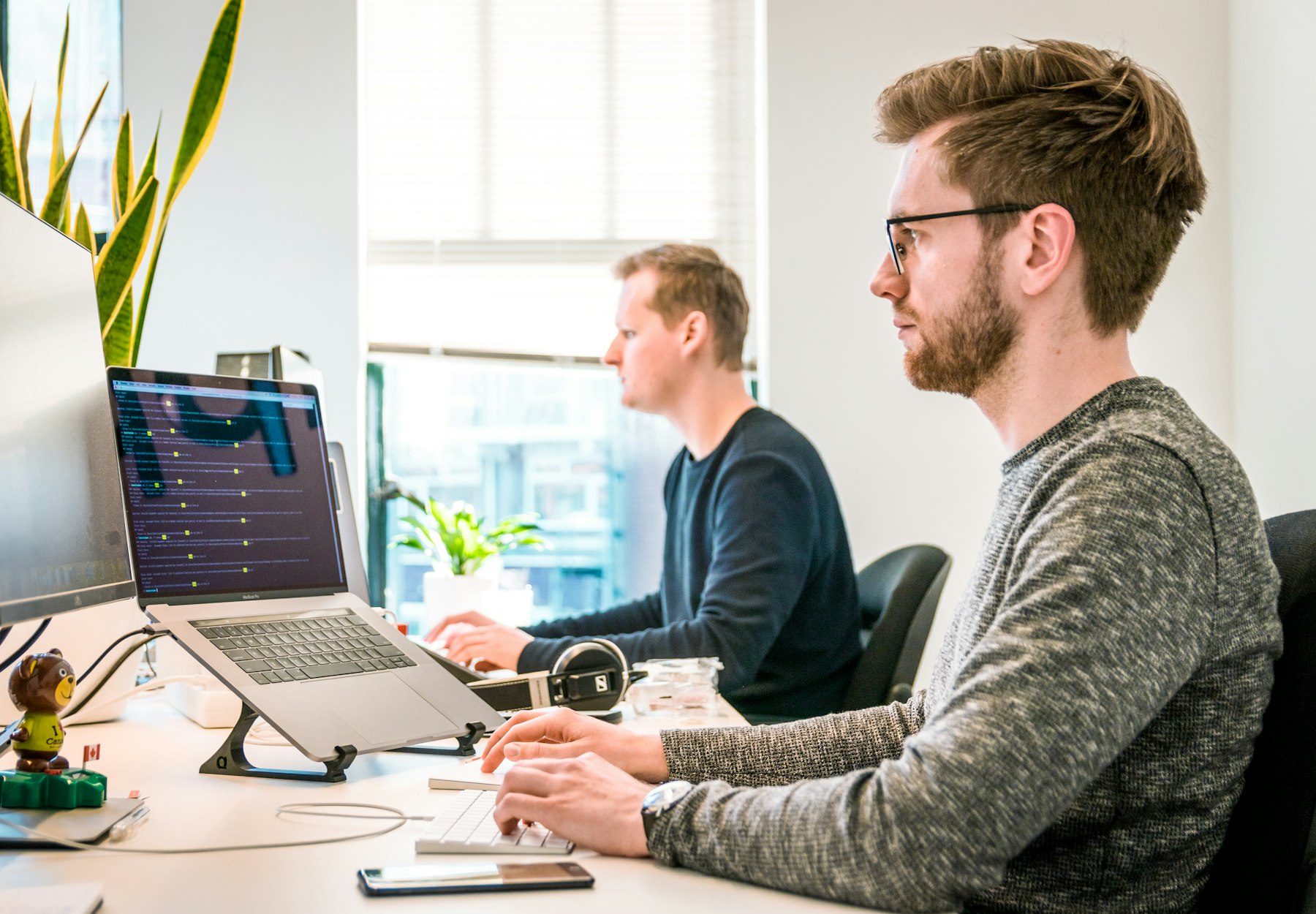Two colleagues collaborating at a workstation in a bright office